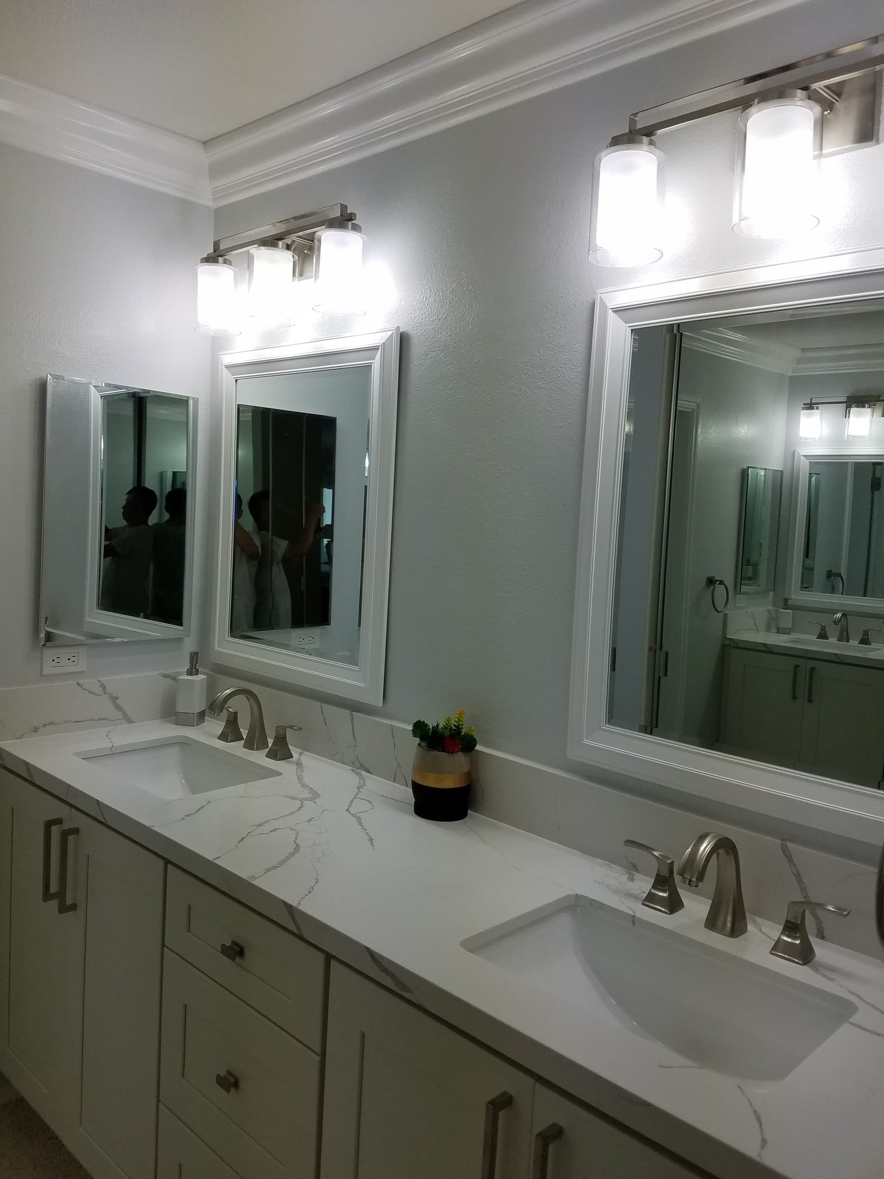 Double vanity with white shaker cabinets, marble-look countertop, framed mirrors and brushed-nickel faucets